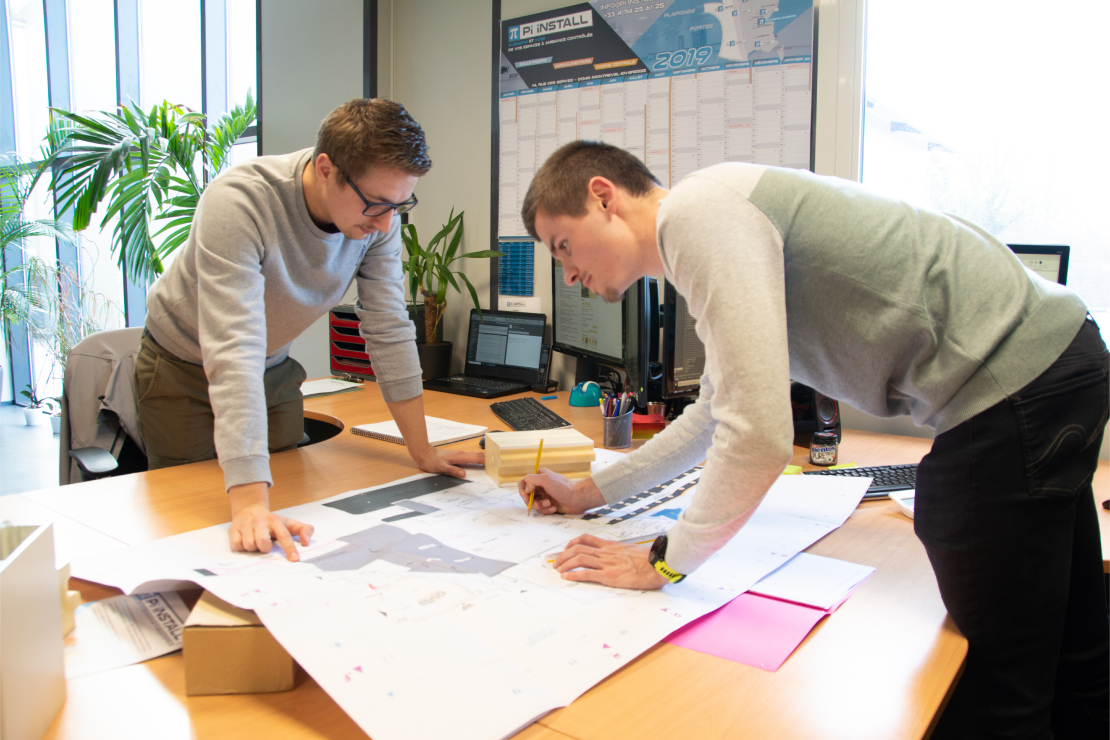 Deux collaborateurs du groupe pi sur un plan